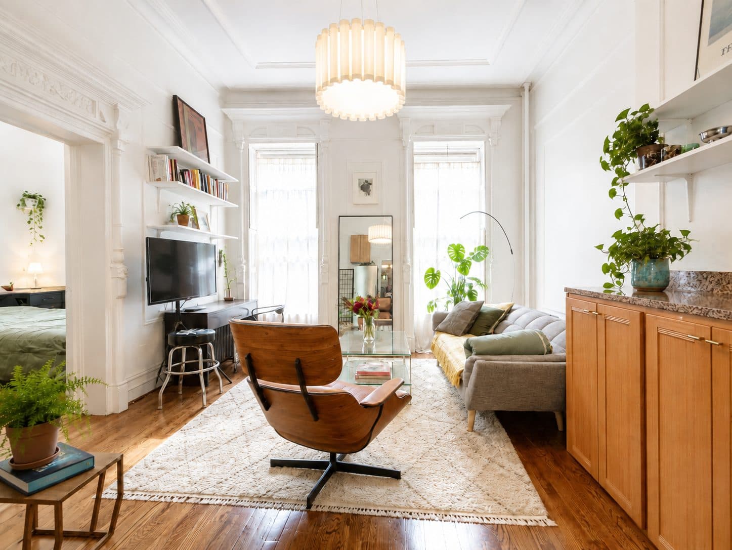 Prewar living room with tall windows and a pendant light, virtually staged
