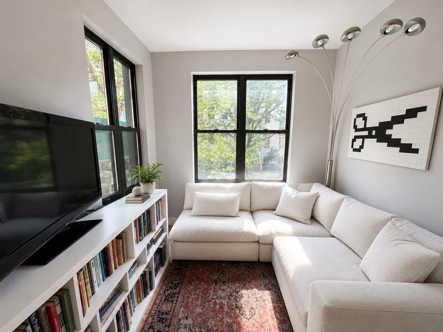 Living room with large black-framed windows and built-in shelving, virtually staged