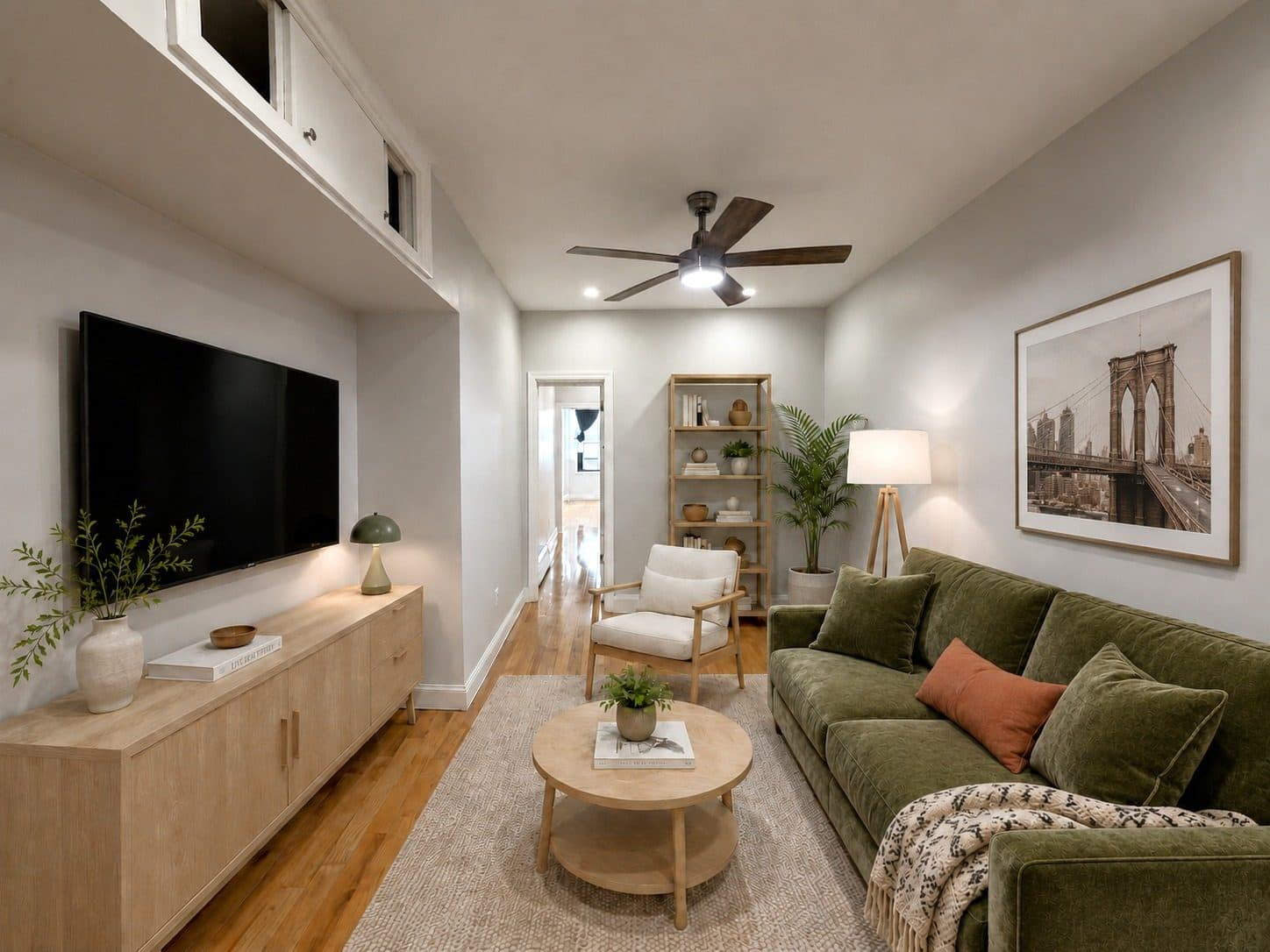 Living room with a ceiling fan and built-in shelving, virtually staged