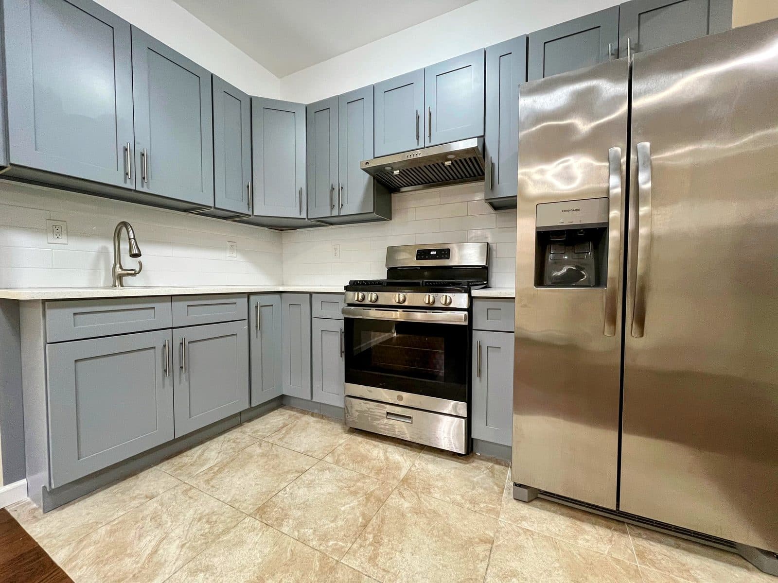 Renovated kitchen with gray shaker cabinets and stainless steel appliances