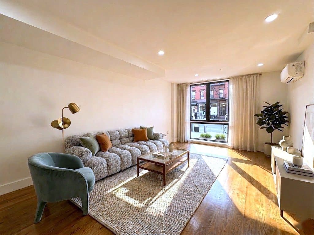Living room with a wall of windows, virtually staged