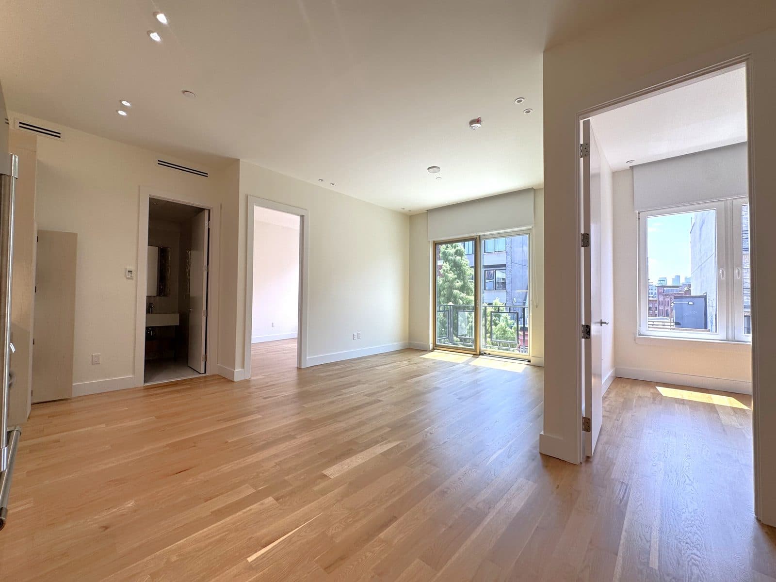 Empty new-construction living room with doors to a balcony
